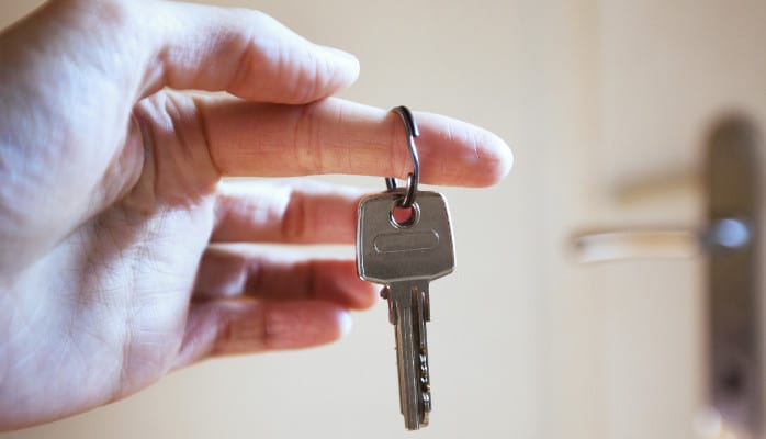 A person holding keys to their new home.