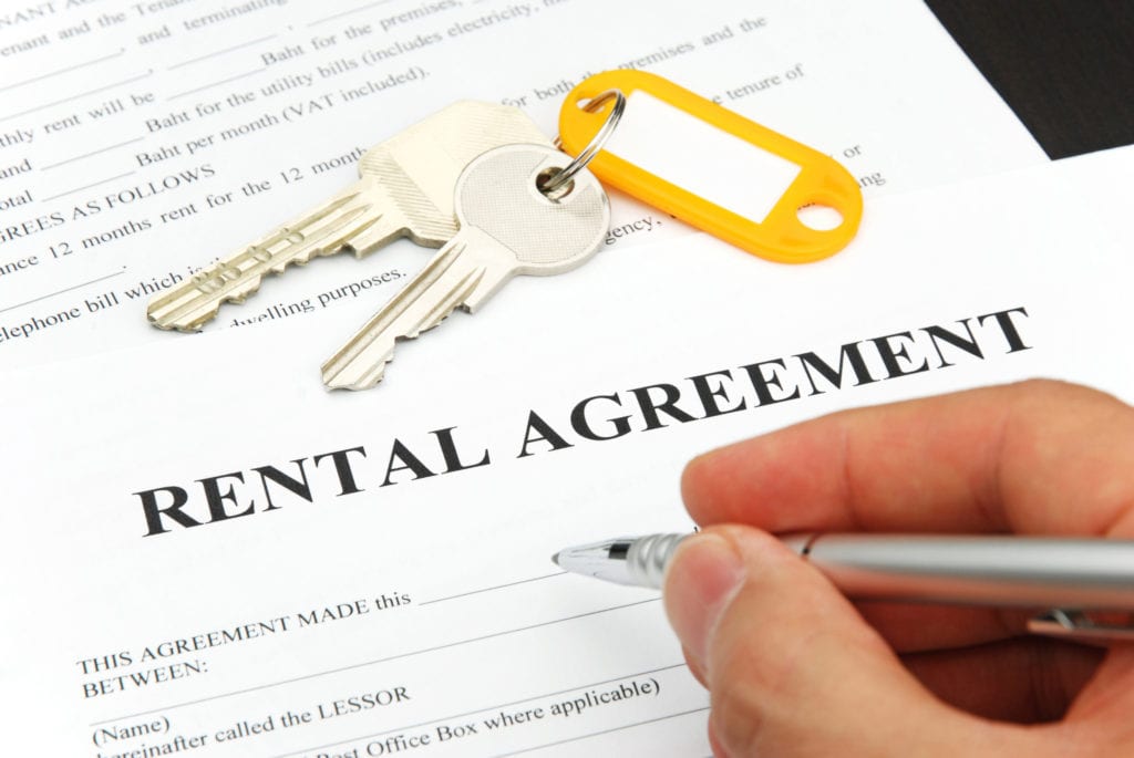 A person is signing a rental agreement